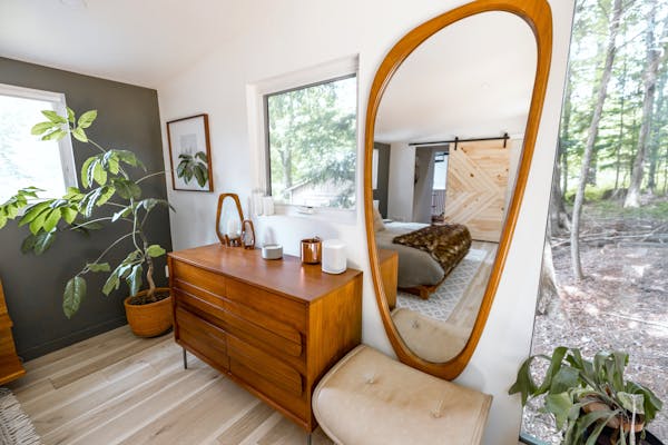 Modern bedroom with wooden furniture and large mirror, ideal for a secondary suite in the GTA