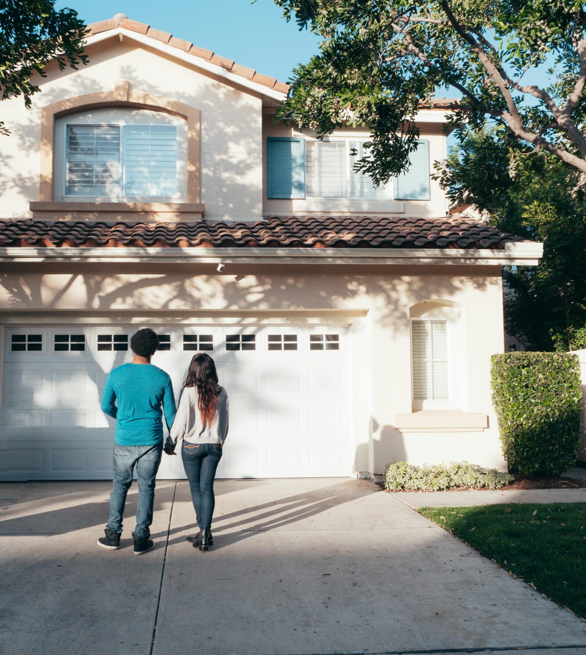 Couple standing in front of their new home, symbolizing joint home buying in Ontario