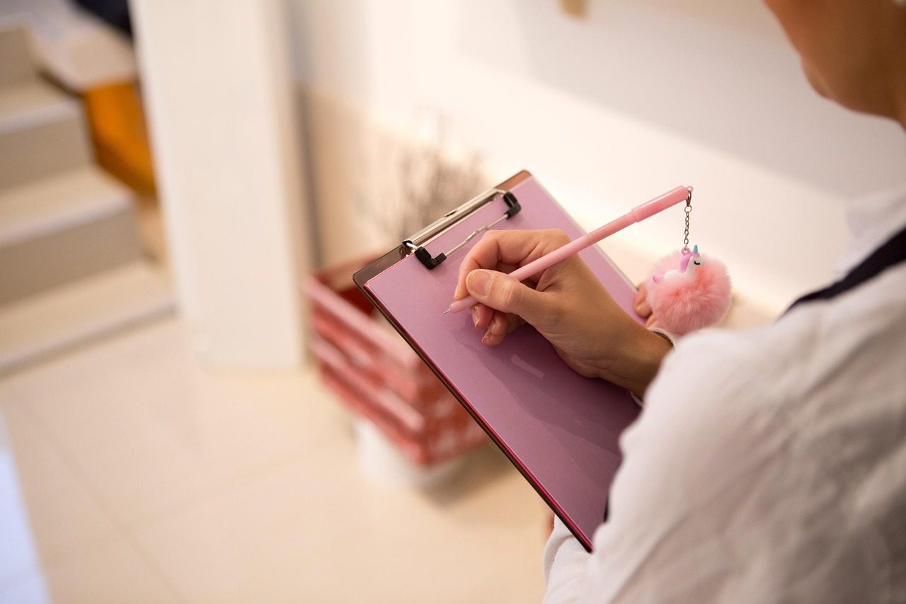 Completing a downsizing checklist and timeline on a clipboard at home