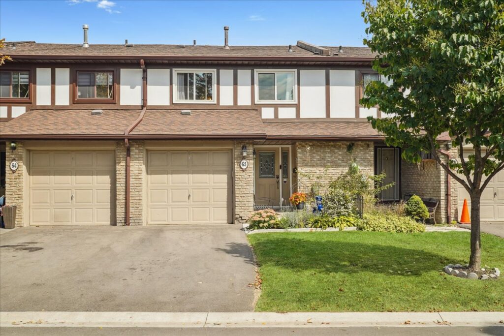 Exterior view of Brampton townhouse with garage and landscaped yard