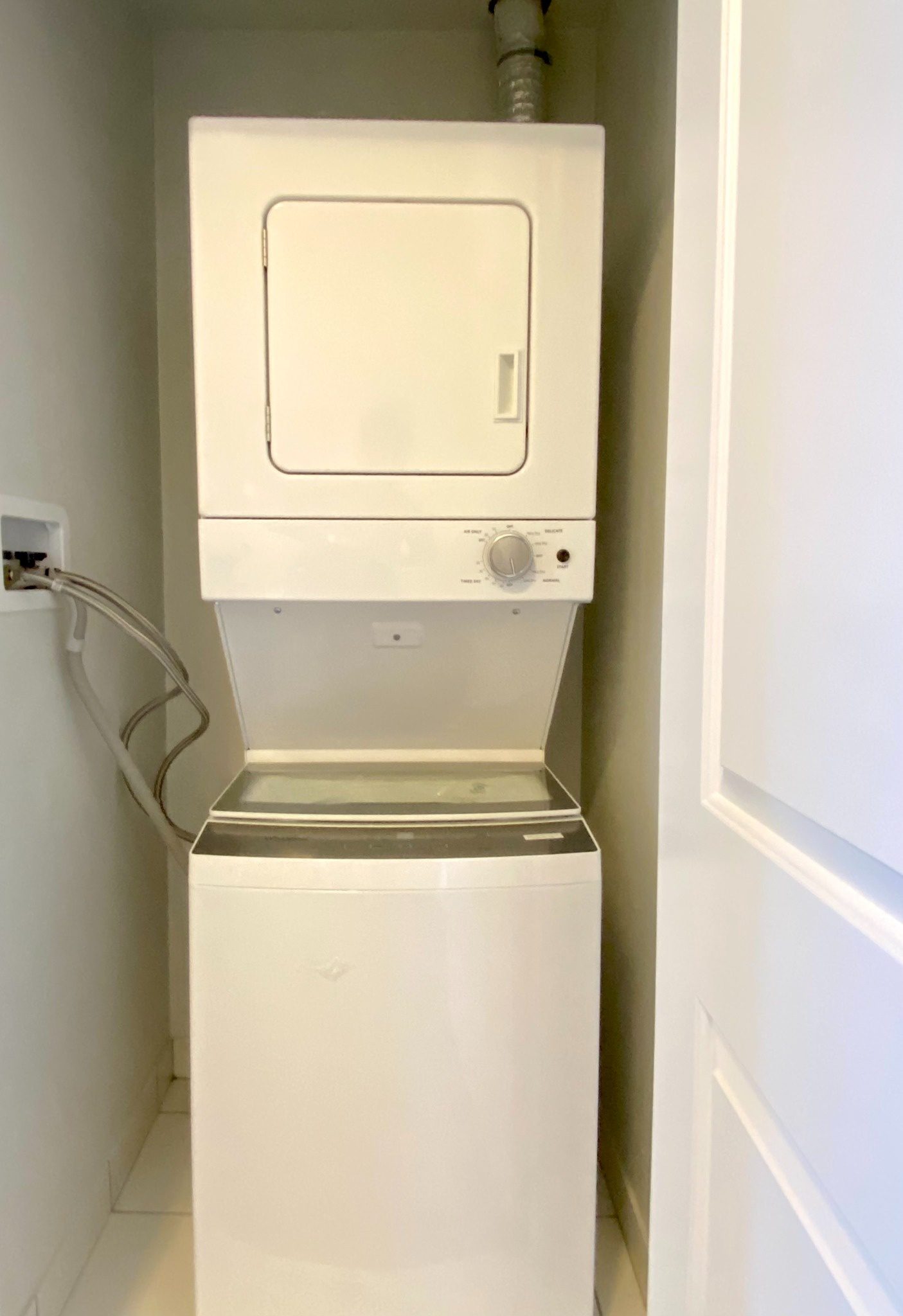 Stack washer & dryer unit inside suite laundry closet.