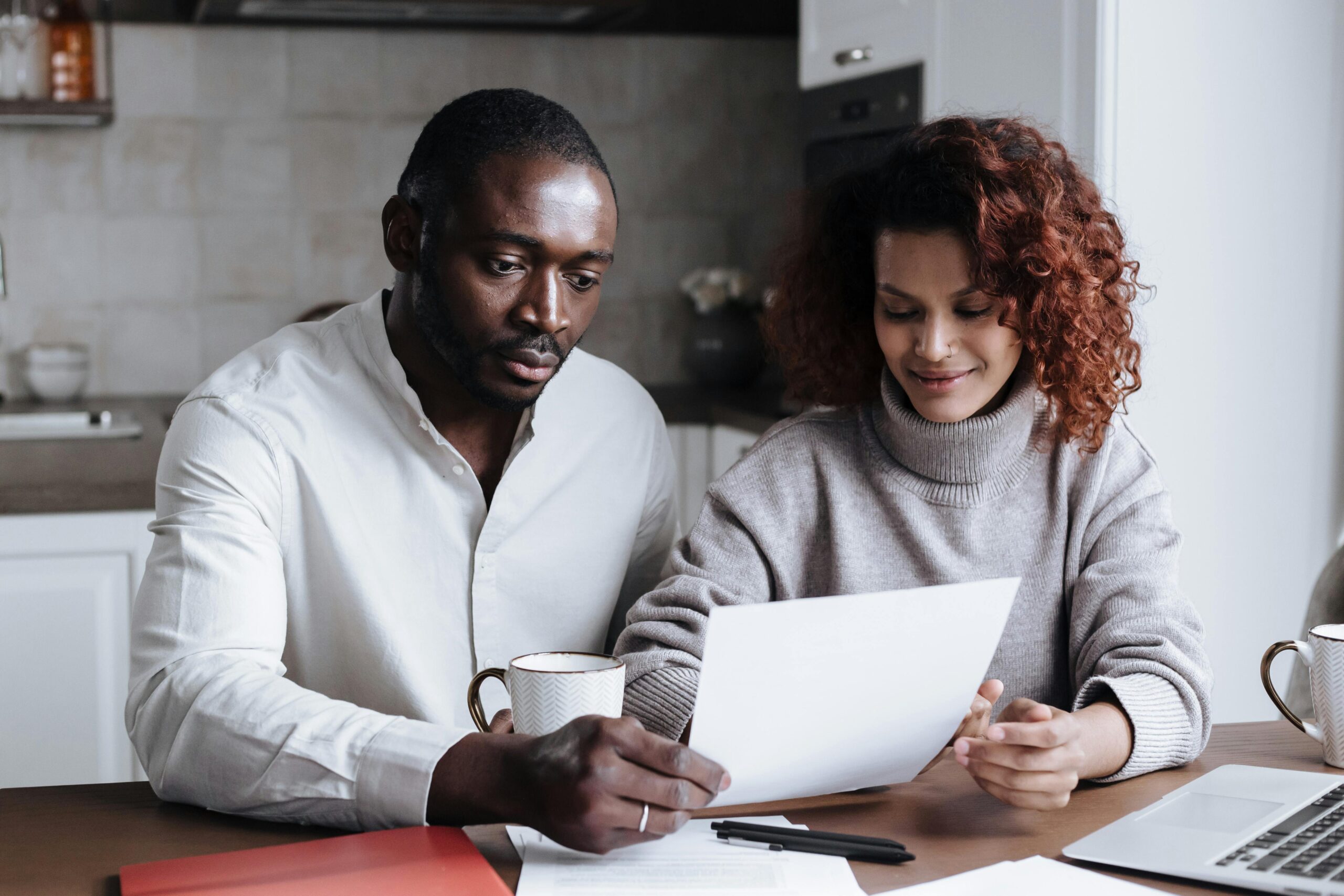 Couple reviewing home buyer program documents at a kitchen table in Ontario.