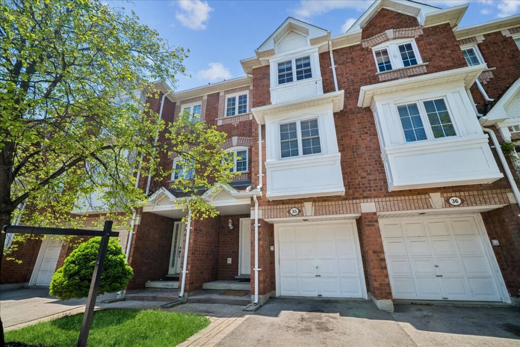 Brownstone-style condo townhome at 6060 Snowy Owl Crescent Unit 35 in Lisgar Mississauga, featuring cathedral ceilings and a private fenced backyard with stone patio.